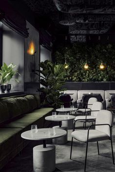 an empty restaurant with tables, chairs and plants