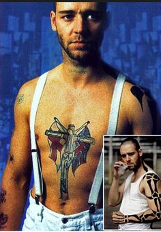 a man with tattoos on his chest and an image of a cross tattooed on his chest