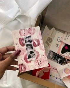 a box filled with lots of different types of cards and pictures next to a person's hand