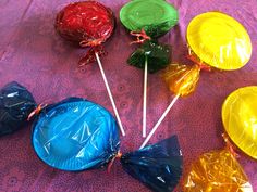 several candy lollipops wrapped in plastic wrappers on a purple tablecloth