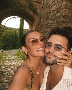 a man and woman posing for a photo in front of an archway