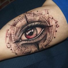 a close up of a person's arm with an eye and compass tattoo on it