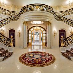 an elaborately decorated entry way leading up to the second floor with stairs and chandeliers