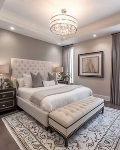 a large white bed sitting in a bedroom next to a window