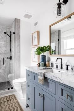 a bathroom with blue cabinets and marble counter tops