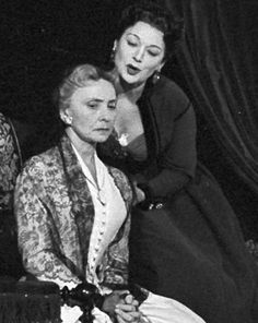 two women sitting next to each other on a stage