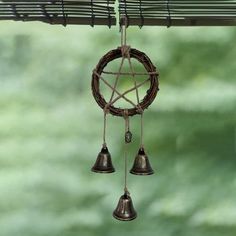 a wind chime hanging from the side of a window with two bells attached to it