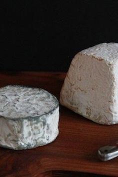 two pieces of cheese sitting on top of a wooden table