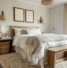 a bedroom with white walls and wooden furniture, including a large bed in the center