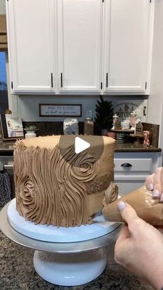 a person is decorating a cake with icing