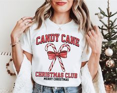 a woman wearing a candy cane christmas t - shirt