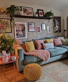 a living room filled with lots of furniture and pictures on the wall above it's couch