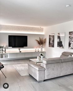 a living room filled with furniture and a flat screen tv mounted to the side of a wall