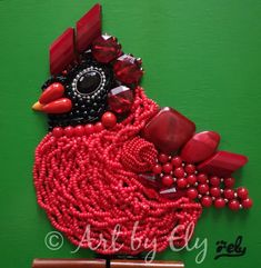 a red beaded bird on a green background