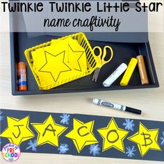 a black tray with yellow stars on it and some scissors, pens and markers next to it