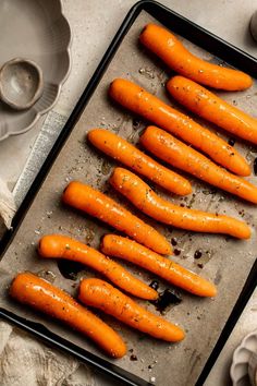 raw carrots on a baking sheet ready to be cooked in the oven with salt and pepper