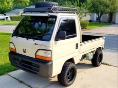 the truck is parked on the side of the road in front of some grass and trees