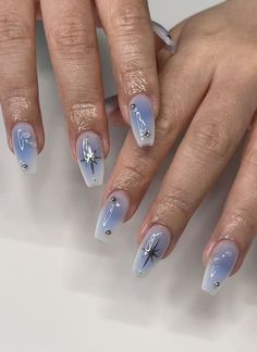 a woman's hands with blue and white nail designs on their fingertipss,