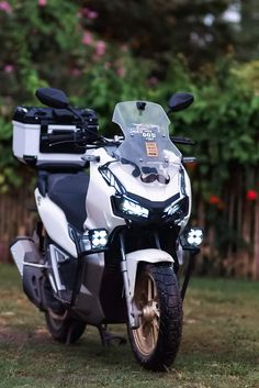 a white and black motorcycle parked in the grass