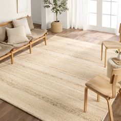 a living room area with two couches, chairs and a rug on the floor