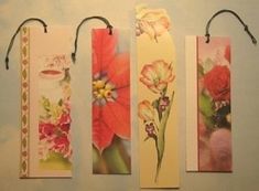 four tags with flowers on them hanging from the wall