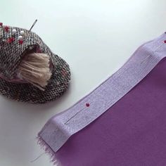 two pieces of fabric sitting next to each other on top of a white table with sewing needles