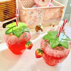 two strawberry shakers sitting on top of a table