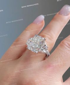 a woman's hand with a large diamond ring on top of her left hand