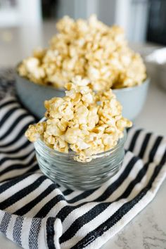 two bowls filled with popcorn sitting on top of a table