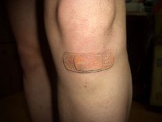 a close up of a person's leg with a small tattoo on the side