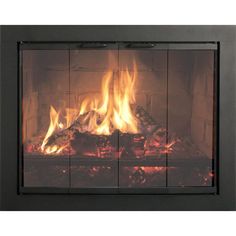 a fire burning in a fireplace next to a wall mounted heater with glass panels