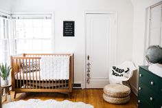 a baby's room with a crib, dresser and bed in the corner