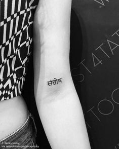 a woman with a small tattoo on her arm and the word tattoos written in it