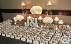 the table is set up with black and white paper bags, candles, and flowers