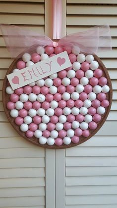 pink and white candies are arranged in a circle on a door hanger that says, i love you