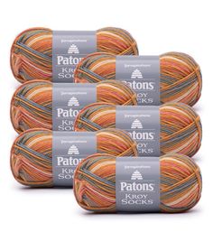 six skeins of patons soft yarn in orange, yellow and grey colors