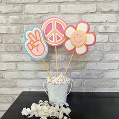 peace, love and flowers on sticks in a bucket next to some paper streamers