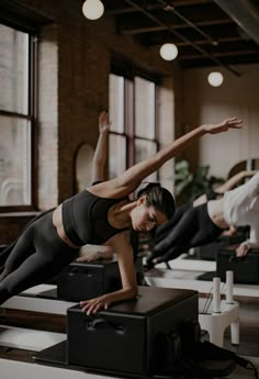 a group of people doing yoga in a room with large windows and lots of luggage