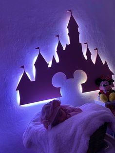 a bedroom with purple lighting and a mickey mouse bed