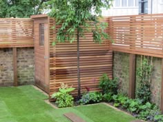 a fenced in garden with grass and trees