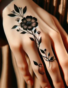 a woman's hand with a flower tattoo on it