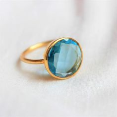 D E T A I L S - Material:  Sterling silver 925Stone:      Blue Topaz Quartz (Lab Created)The fit:     True to US ring size Finish:      Smooth and Gold Plated to a high shineS H I P P I N G & P R O D U C T I O N - My current production time is 2-6 business days, which means after those days are up, your order ships! I make everything custom to order, by hand, but I promise you it's worth the wait!R U S H - M Y - O R D E R -If you're in a rush to get your pretty new pieces, please send me a m Blue Birthstone Crystal Ring, Turquoise Topaz Ring, Blue Topaz Ring With Bezel Setting For Gift, Blue Topaz Ring With Bezel Setting As Gift, Blue Solitaire Ring Gift, Blue Faceted Sapphire Ring For Wedding, Blue Round Crystal Ring In Fine Jewelry Style, Turquoise Topaz Ring Fine Jewelry, Blue Solitaire Crystal Ring