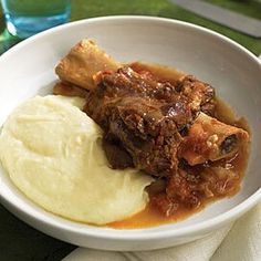 a white bowl filled with meat and mashed potatoes