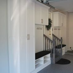 an empty room with white cupboards and black floor mats on the floor next to stairs