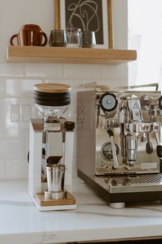 an espresso machine sitting on top of a counter next to a coffee maker