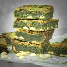 several pieces of green cake sitting on top of each other next to some white chocolate chips