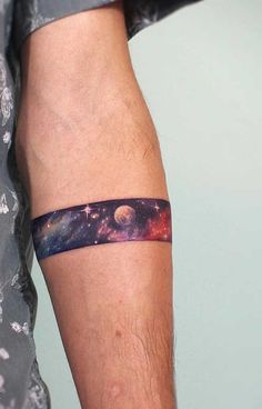 a man's arm with a space themed tattoo on the left side of his arm