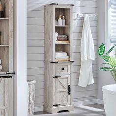 a bathroom with white walls and wooden cabinets in the corner next to a potted plant