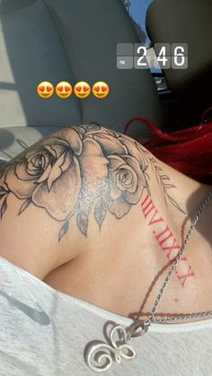 the back of a woman's neck with roses on it and an arrow tattoo