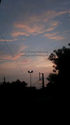 the sun is setting behind some power lines and telephone poles with a quote on it